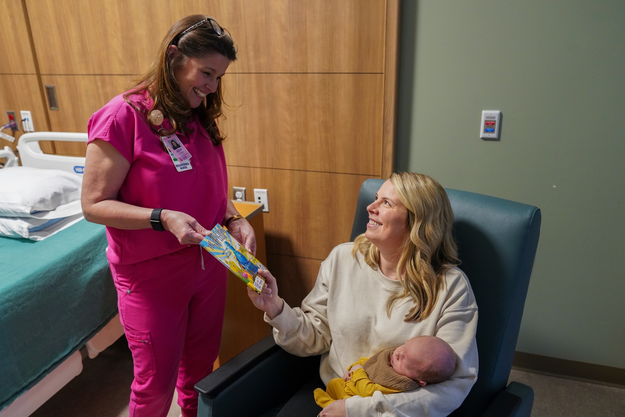 Norman Regional Nurse gives a book to a patient for Build a Brain Program.