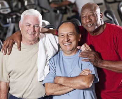 3 older men smiling in a gym