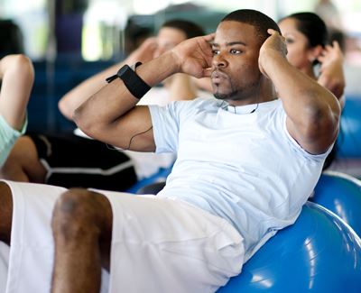 man doing core exercises using a yoga ball